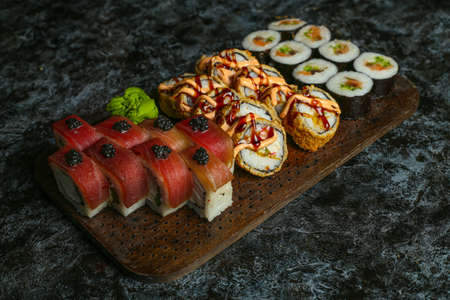 Traditional delicious fresh sushi roll set on a black background with reflection. Sushi roll with rice, red fish, salmon. Sushi menu. Japanese kitchen, restaurant. Seafood, asian foodの写真素材