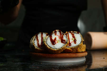 Hot fried Sushi Roll with salmon, avocado and cheese. Sushi menu. Japanese food.の写真素材