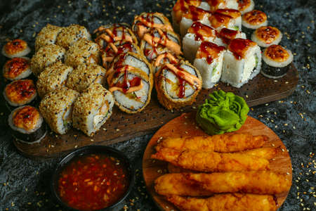 Traditional delicious fresh sushi roll set on a black background with reflection. Sushi roll with rice, red fish, salmon. Sushi menu. Japanese kitchen, restaurant. Seafood, asian foodの写真素材