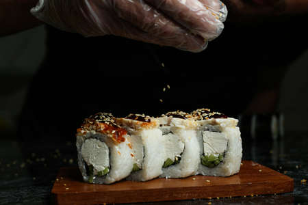 Traditional delicious fresh sushi roll set on a black background with reflection. Sushi roll with rice, red fish, salmon. Sushi menu. Japanese kitchen, restaurant. Seafood, asian foodの写真素材