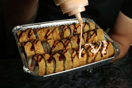 Hot fried Sushi Roll with salmon, avocado and cheese. Sushi menu. Japanese food.の写真素材