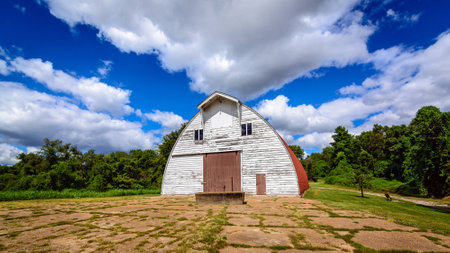 Old White Barn with blue cloudy skies retreating to vanishing pointの写真素材