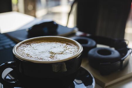 Studying wiht a delicious latte surounded by study materials and electronics.の写真素材