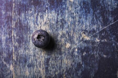Isolated fresh blueberry on a distressed blue wood background.の写真素材