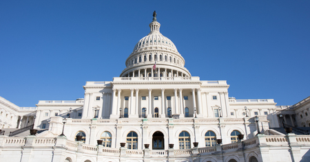 Looking up at the back of The Capitol Building in Washington, D.C. with a bright blue sky.の写真素材