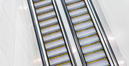 Both sets of up and down escalators in a hotel convention center with no one riding them.  and down...