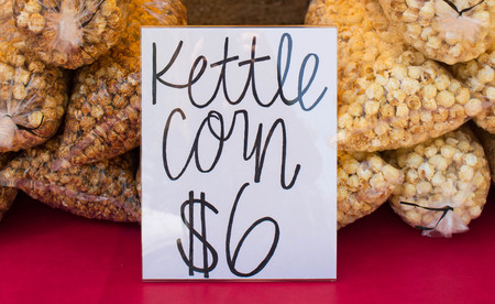 Bagged kettle corn for sale at a summer farmers market or fair.の写真素材