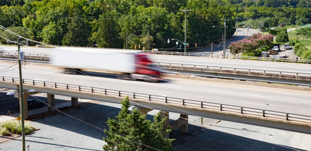 A semi truck crossing over a bridge taken with slow shutter speed to show movement and speed.の写真素材