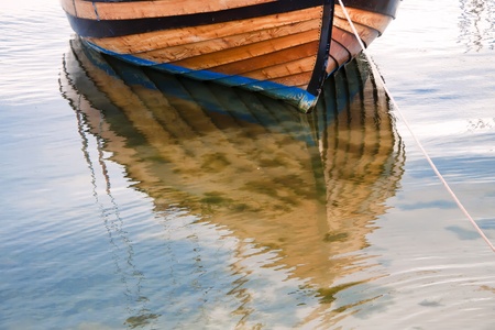 Fishing boat in port against blue water.