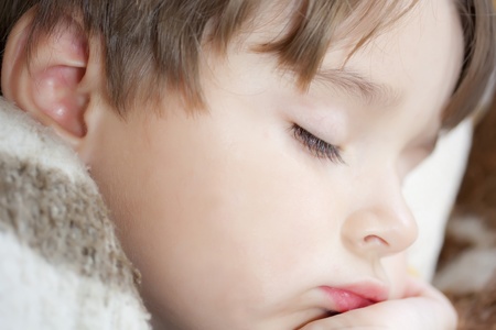 Little boy sleeping under blanket.の写真素材