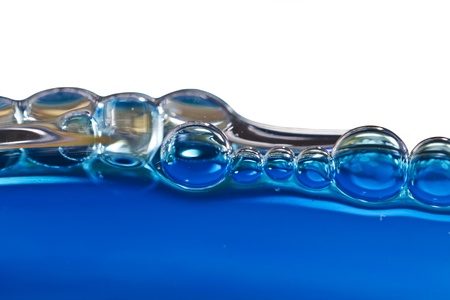 Blue bubbles in clear water against whiteの写真素材