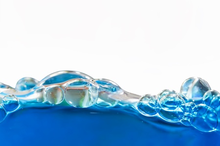 Blue bubbles in clear water against whiteの写真素材