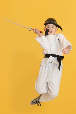 Boy age 7 fighting like karate playerの写真素材