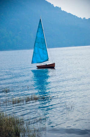Portrait of a sailing boat, a yacht on the water in a lakeの写真素材