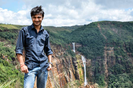 Young man standing and happy with the fresh and mind-blowing beauty of nature. Joyful young boy enjoying the natureの写真素材