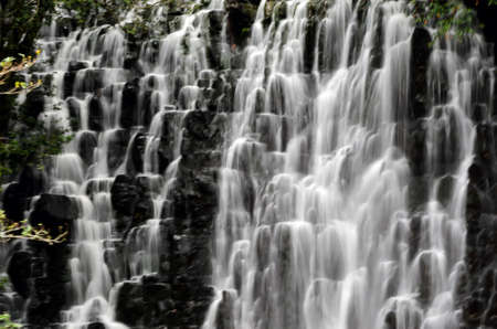 Waterfall with slow shutter speed to create milky water. High mountain and water cascading in milky...