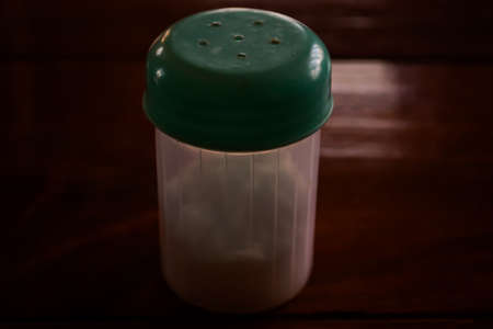 Closeup of a salt or black pepper jar on the wooden textured table to serve the customers for breakfast, lunch, and dinner.の写真素材