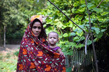 Gowainghat, Bangladesh - November 06, 2019: A healthy mother with a healthy baby standing in front...