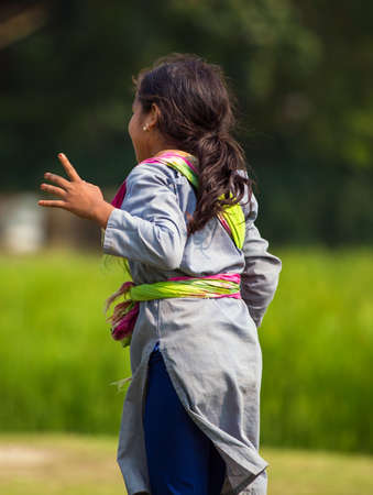 Gowainghat, Bangladesh â November 06, 2019: A teenage girl playing on the school field. Beautiful girl from the rural village dancing and enjoying the break time.のeditorial素材