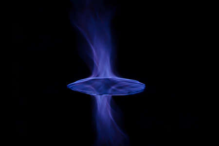 Blue fire flame isolated in black background. Blue and red flames reflected in up and down