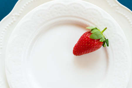 Strawberry placed on white empty plateの写真素材