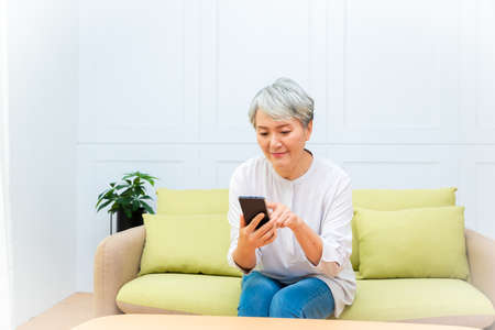 Senior asian woman holding Cell phone using mobile online apps.