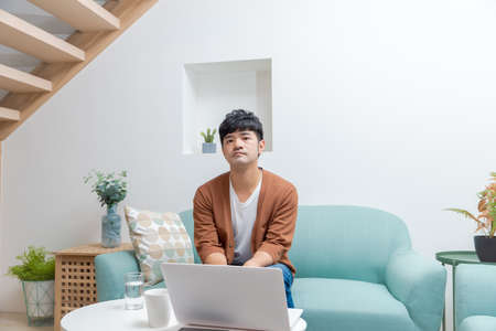 A young man working at home with a laptopの写真素材