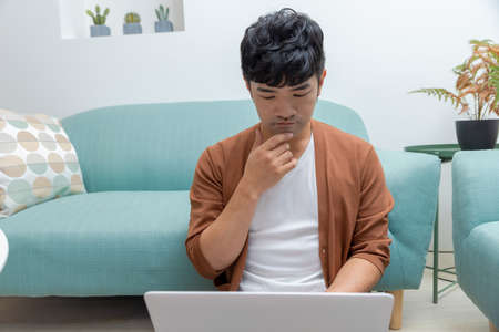 A young man working at home with a laptopの写真素材