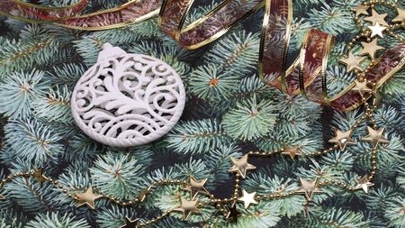 Christmas composition of white glittering ball shaped toy, red ribbon 
and gold star garland on green pine surface. Top viewの写真素材