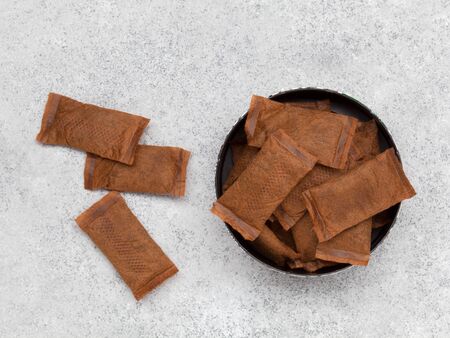 Open can of smokeless tobacco on grey stone background. Top view