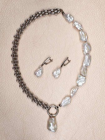 Set of baroque pearls on beige leather background. Close-up shot