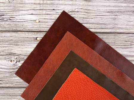 Different colors natural leather textures samples on light wooden backgroundの写真素材