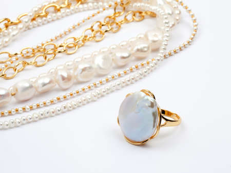 Luxury elegant baroque pearl golden ring with necklaces on white background. Close-up shot
