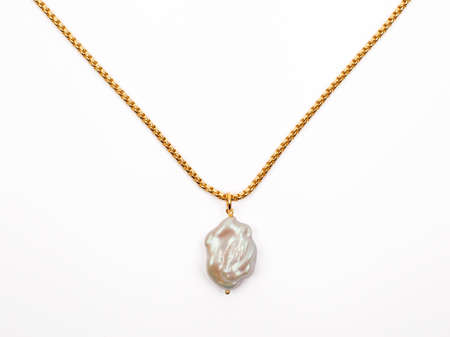 Luxury elegant baroque pearl pendant with golden chain isolated on white background. Close-up shotの写真素材