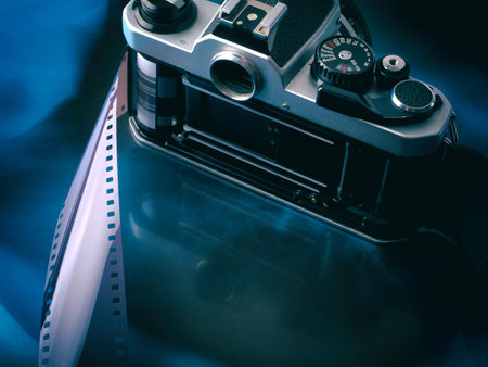 Open old vintage film camera with film strip on abstract gradient blue black background. With copy spaceの写真素材