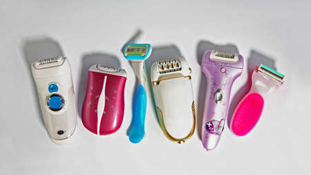 Different shaving razors and epilators on gray background. Flat layの写真素材