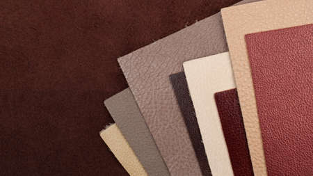 Different colors natural leather textures samples on brown background