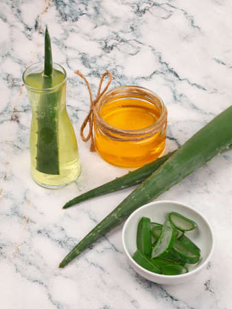 Aloe Vera and honey closeup on light marble background. Sliced Aloe vera natural organic renewal cosmetics, alternative medicine, organic skin care conceptの写真素材