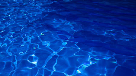 Abstract blue texture of swimming pool water with reflections