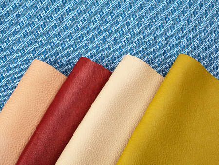 Different colors natural leather textures samples on blue fabric backgroundの写真素材