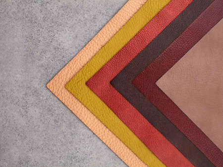Different colors natural leather textures samples on gray stone background