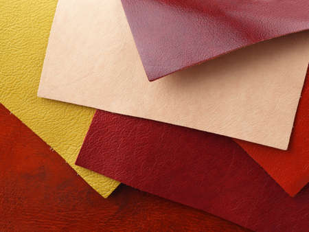 Different colors natural leather textures samples on red leather backgroundの写真素材