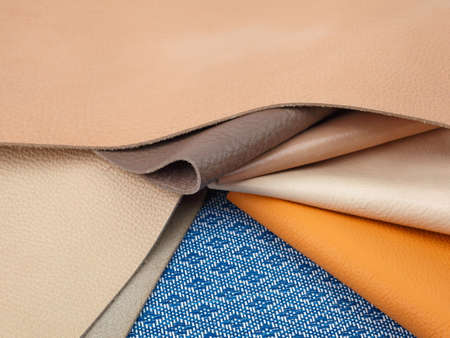 Different colors natural leather textures samples on blue fabric backgroundの写真素材