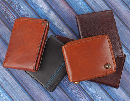New leather multicolored wallets on blue wooden background. Top viewの写真素材