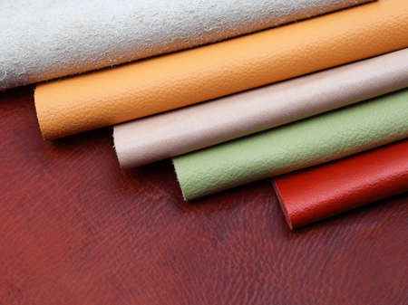 Different colors natural leather textures samples on brown leather backgroundの写真素材