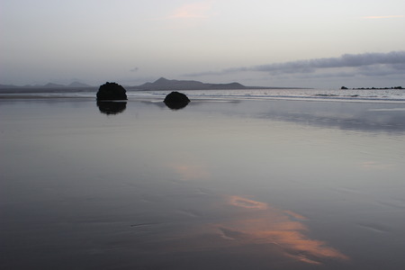 calm sunset at the beach with stonesの写真素材