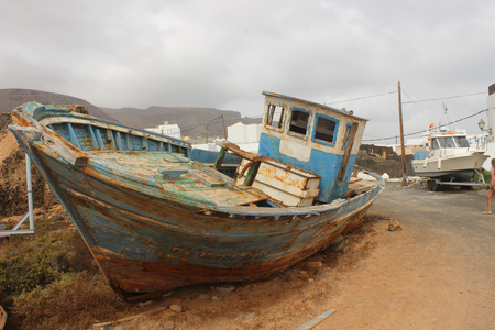 old abandoned fisherboat shipwreck at the coastの写真素材