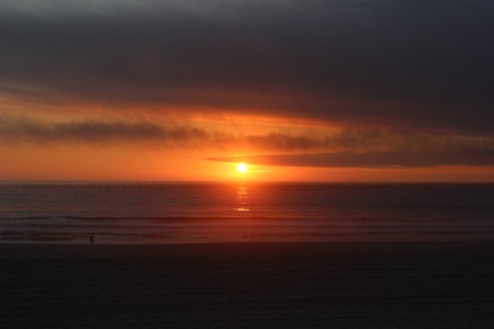 Dramatic sunset at the beach with cloudy skyの写真素材