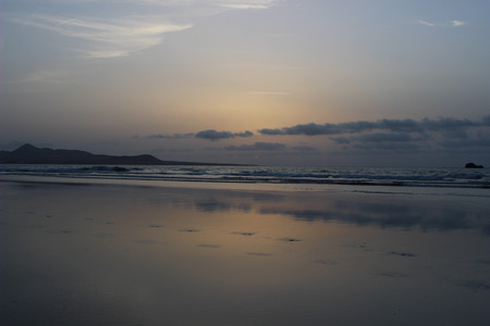 idyllic sunset at the beach with calm oceanの写真素材