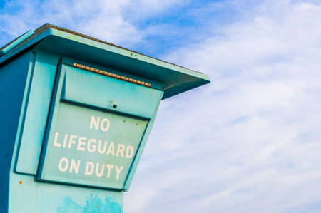 sign saying No Lifeguard On Duty  on a lifeguard tower at a beach in Californiaの写真素材